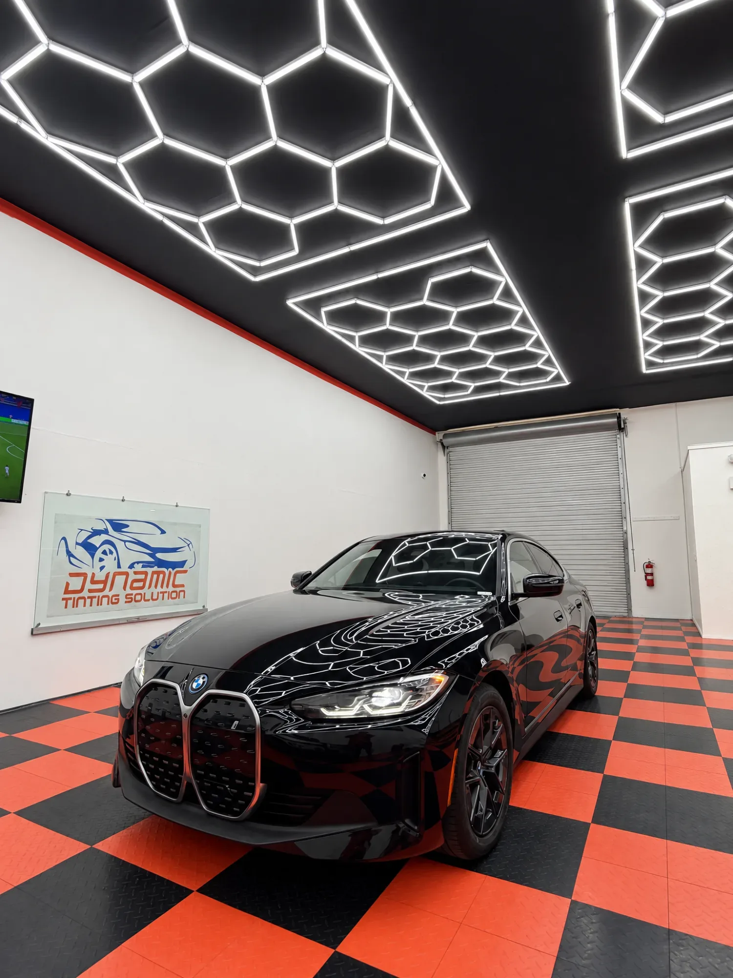 Black BMW i4 in the Dynamic Tinting Solution shop in Largo, FL, with tinted windows