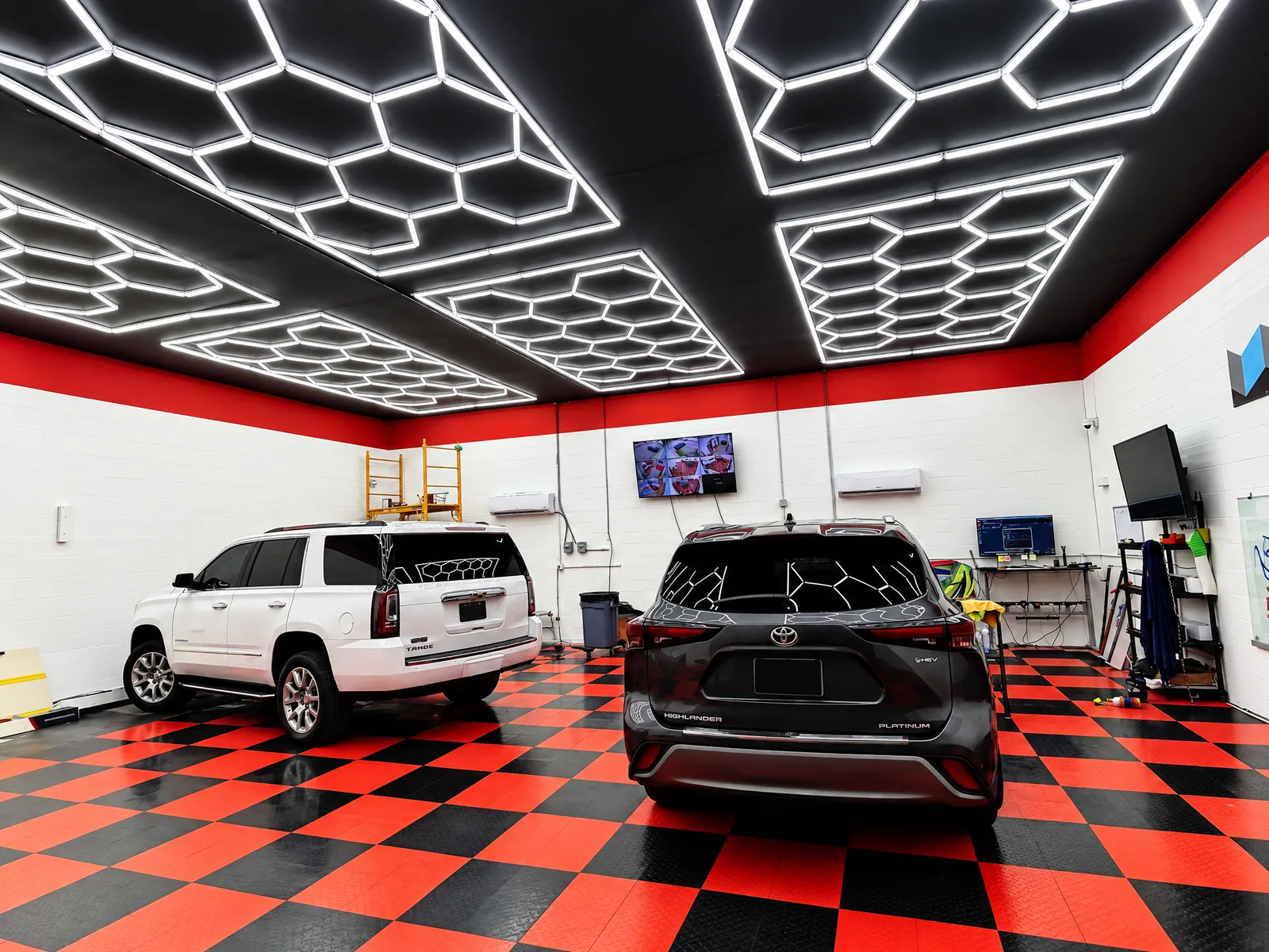 White Chevrolet Tahoe and black Toyota Highlander in the Dynamic Tinting Solution shop in Largo, FL